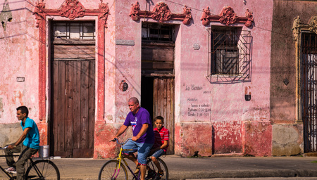 Camaguey, Cuba on January 3, 2016: Cuban men riding bicycles through a street in the historic Caribbean city center of Camagueyのeditorial素材