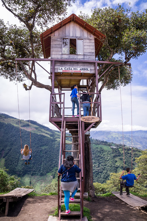 Banos, Ecuador on November 18, 2015: Tourists enjoying the giant swing at the treehouse Casa del Arbol in the Andes near Banos, Ecuador. The view from the swing is breathtaking.のeditorial素材