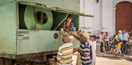 Sancti Spiritus, Cuba on January 1, 2016: Cuban men buying beer from a truck to celebrate New Year. Homebrew beer is popular in Cuba and very cheap, 700ml costs only 3 CUP, ca. 0,12 USDのeditorial素材
