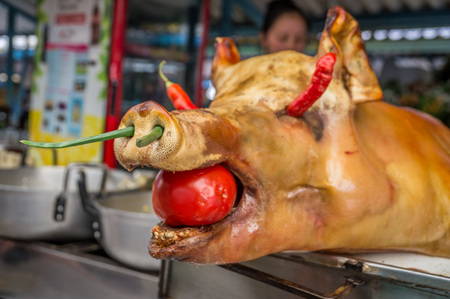 Roasted pig decorated with vegetables on a market in Ecuadorの写真素材