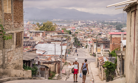 Santiago de Cuba, Cuba on January 4, 2016: Women walking down street in poor residential areaのeditorial素材