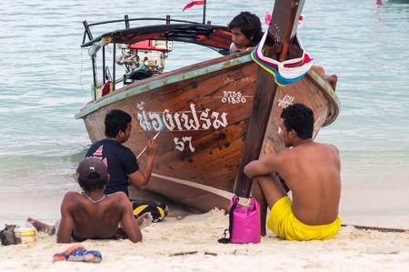 Ko Lipe, Thailand on November 10, 2016: Thai men painting a longtail boatのeditorial素材