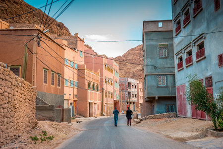 Tinghir, Morocco on February 26, 2018: Two men walking at a street in Tinghir, Morocco surrounded by...