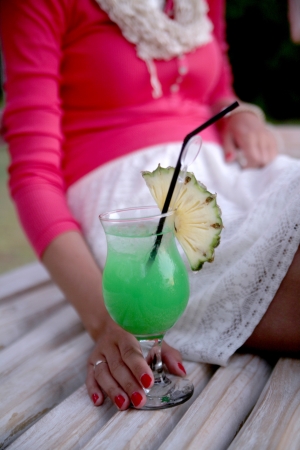 Woman hand with cocktail glass near swimming pool の写真素材