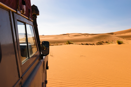 Off- road vehicle oldtimer in Sahara dunes, Moroccoの写真素材