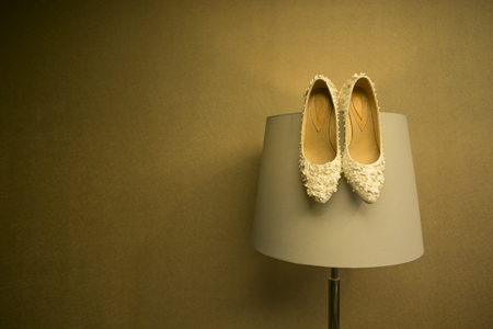 Pair of shoe for wedding day hanging on the lampの写真素材