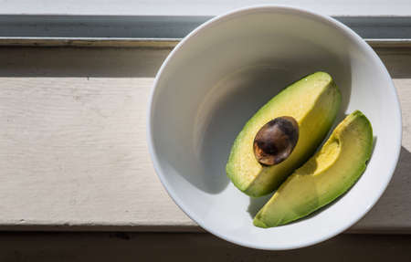 the cut avocado on the white plateの写真素材