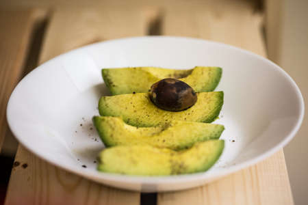 the cut avocado on the white plateの写真素材