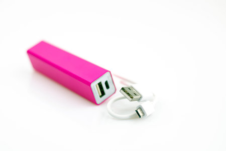 Magenta power bank isolated on white background with USB cable