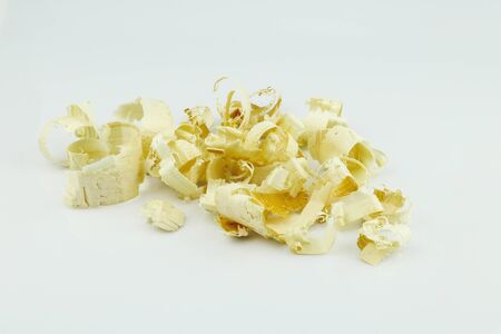 Wood shavings isolated on white background. A pile of yellow sawdust wood pieces on a white backgroundの写真素材