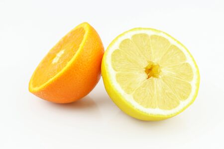 Fresh lemon and orange halves isolated on white background. Yellow fresh sliced lemon and orange separated on white backgroundの写真素材