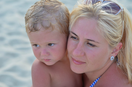 Mother and son are sitting on the beachの写真素材