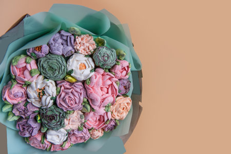 Festive bouquet of sweet sugar marshmallow rose flowers on beige isolated white background. Mockup place for text. Edible flowers, small business, hobby. Delicious holiday gift. Natural organic bakingの写真素材