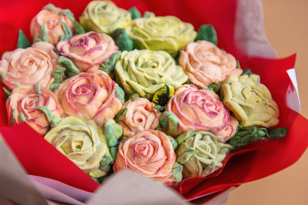 Close up bouquet of sweet sugarlles marshmallow rose flowers on white isolated beige background. Edible flowers, small business hobby. Delicious holiday gift. Natural organic baking. Handmade presentの写真素材