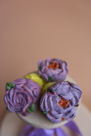 On wooden round background lie natural marshmallows in the form of purple peony flowers. Sweet desserts without sugar. Creative baking confectioners. Copy space, mock up. Sweet food. Isolated orangeの写真素材