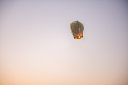 Chinese, paper, yellow lantern in the blue sky at sunset. Making wishes. Earth pollution. Copy spaceの写真素材