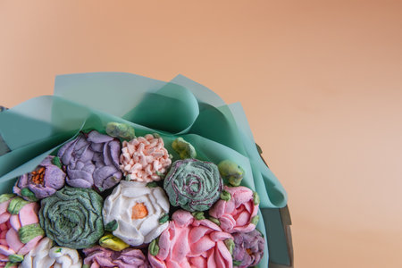 Festive bouquet of sweet sugar marshmallow rose flowers on beige isolated white background. Mockup place for text. Edible flowers, small business, hobby. Delicious holiday gift. Natural organic bakingの写真素材