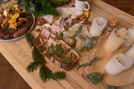 On wooden table are rustic materials for creative decoration of Christmas interior. Fir branches...