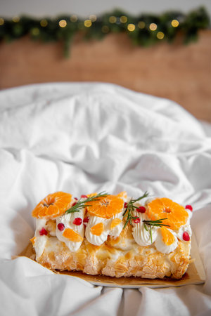 Close-up of delicious Meringue Roll with Orange Curd, layered dessert with oranges, pomegranate...