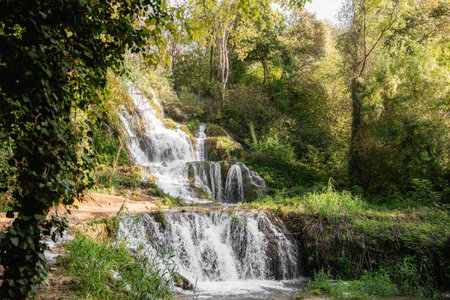 Beautiful waterfalls flowing through lush green vegetation during summer in Krka national park, Croatia, creating a picturesque natural landscapeの写真素材