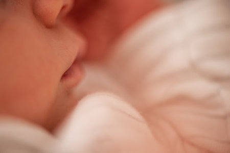 Close-up of a newborn baby sleeping peacefully, highlighting the delicate features of the tiny nose and soft lips, radiating tenderness and a sense of calm tranquilityの写真素材