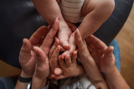 Mother and father lovingly holding the tiny feet of their newborn, showcasing the deep family bonds and tenderness that define their relationship in this intimate momentの写真素材