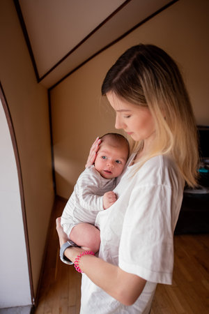 Mom cradling her newborn child in her arms, enveloping both in a warm atmosphere filled with love...
