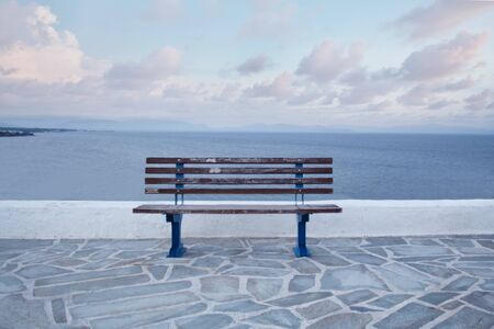 Wooden bench in front of the seaの写真素材