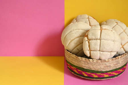 creative photo closeup of delicious homemade Mexican vanilla shells in traditional wicker basket on pink and yellow plaid backgroundの写真素材