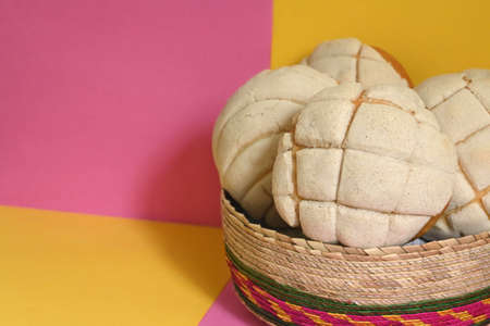 creative photo of delicious homemade Mexican vanilla shells in traditional wicker basket on pink and yellow plaid backgroundの写真素材