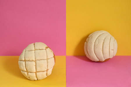 Creative photography closeup of two traditional Mexican vanilla shells on a pink and yellow plaid backgroundの写真素材