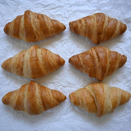 Close-up delicious traditional golden croissants on paper backgroundの写真素材