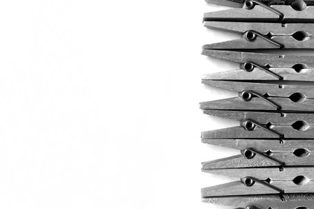 Close-up of black and white photography of clothespins on white background, with copy space