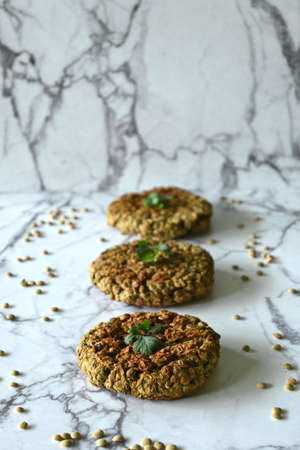 Lentil burgers vertical closeup, marble background and copy spaceの写真素材