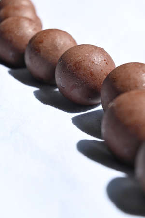 Row of chocolate balls with hard shadowsの写真素材
