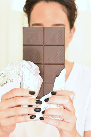 Chocolate bar in the hands of a young woman