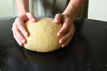 Woman's hands surrounding a ball of doughの写真素材