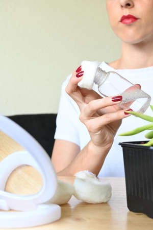 selective focus on make-up remover bottle held by young womanの写真素材
