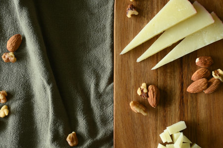 Top view of manchego cheese board with almonds and walnuts