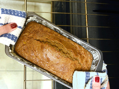 sponge cake being taken out of the oven by a woman's hands