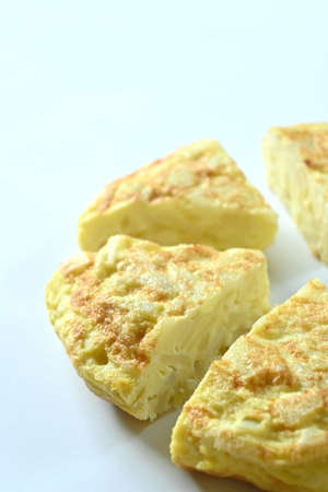 Close-up of spanish omelet cut in pieces, white background and copy spaceの写真素材