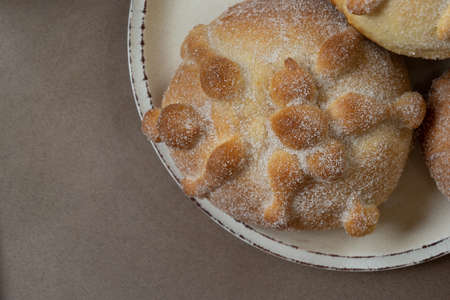 Overhead shot of homemade mexican pan de muerto, select focus, beige tones, beige background and copy spaceの写真素材