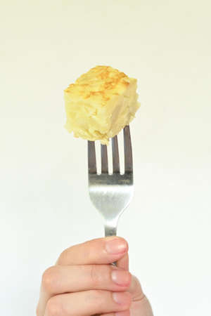 Close-up of piece of spanish omelet, white background and copy spaceの写真素材