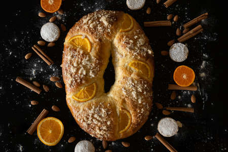 Top view of traditional roscÃ³n de reyes with ingredients around, with black background, Christmas concept.の写真素材