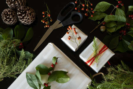 Top view of Christmas gifts decorated with natural Christmas plants, black backgroundの写真素材
