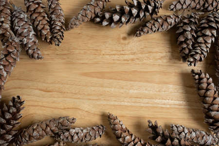 Top view of frame of natural pine cones on wood, with copy space.の写真素材