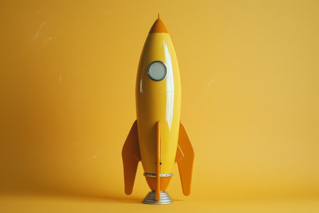 Vibrant yellow toy rocket stands against a solid orange backdrop, symbolizing innovation and explorationの素材