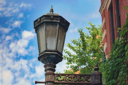 Ornate vintage gaslight is standing on a city street corner, illuminating the way for passersbyの素材