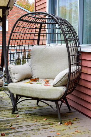 Outdoor patio with armchair and wicker birdcage.の写真素材