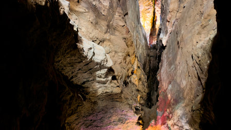 Majestic Cave Interior with Vertical Rock Crevice and Warm Illuminationの写真素材